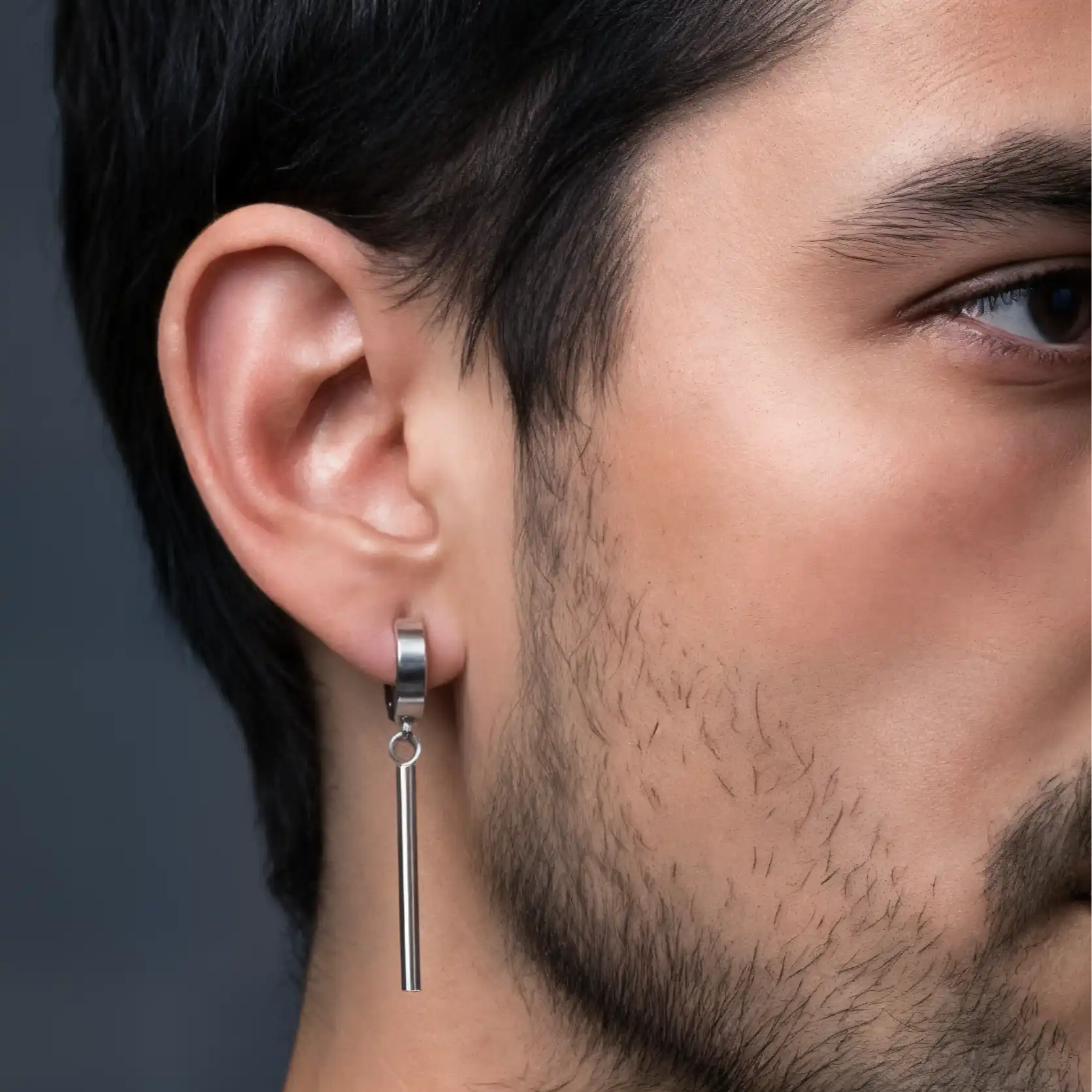 Une boucle d'oreille en barre d'argent sur l'oreille d'un homme.