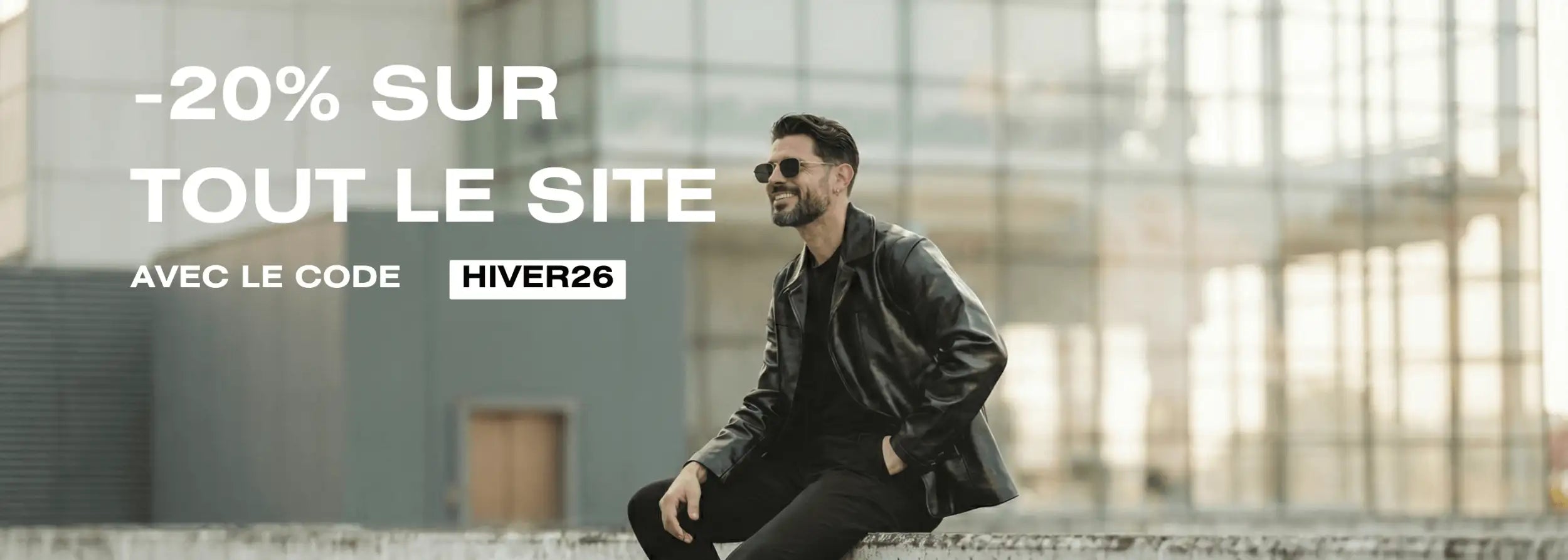 Un homme portant une veste en cuir noir et des lunettes de soleil.