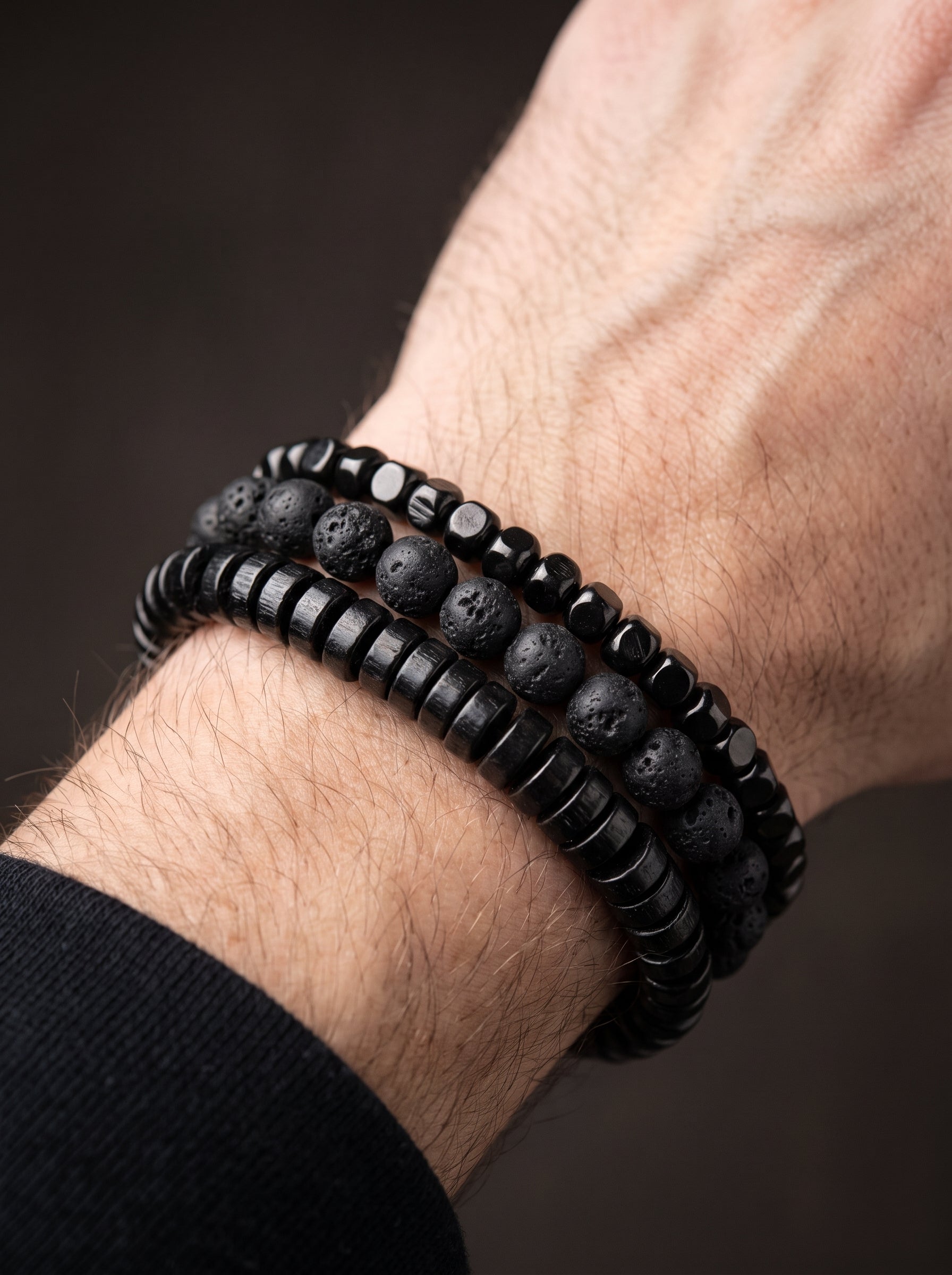 Bracelet de perles en pierre de lave porté au poignet d'un homme
