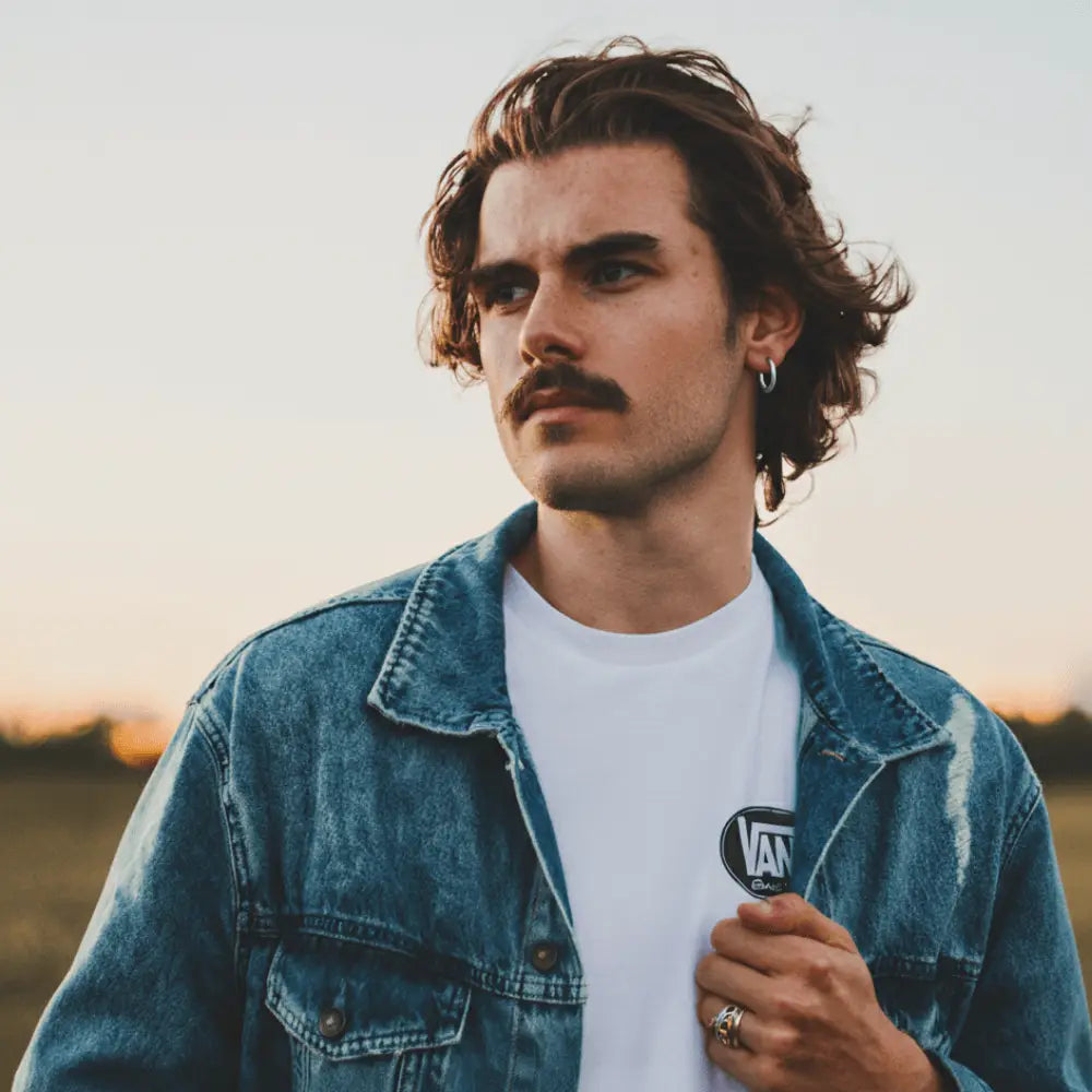 Homme portant une boucle d'oreilles avec cheveux mi longs